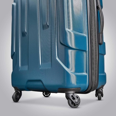 El equipaje expandible de lado duro con ruedas giratorias, de color azul, de mediano y de 24 pulgadas.